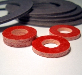 Arandelas de materiales aislantes eléctricos dispuestas sobre fondo blanco